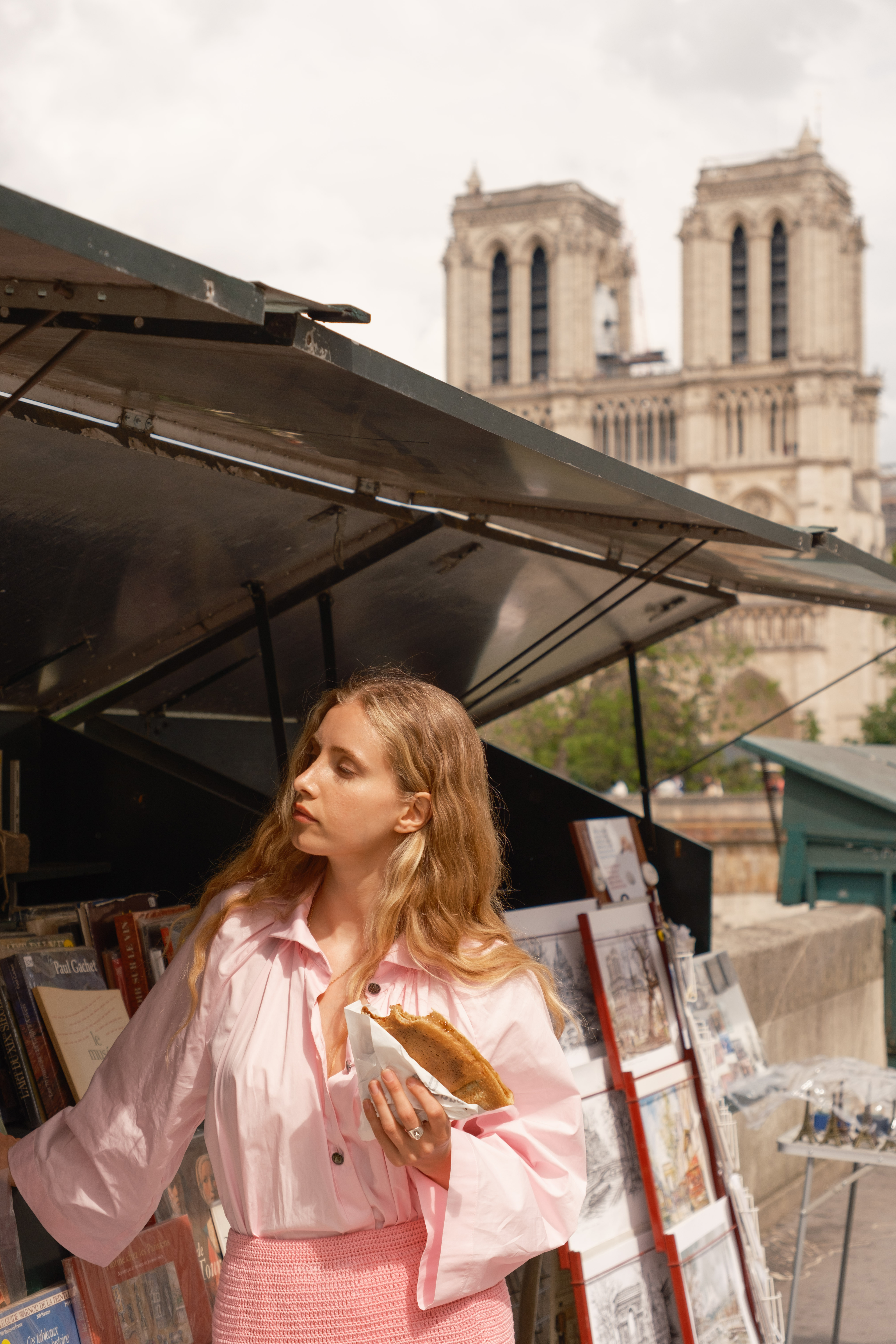 a woman standing under a tent with a sandwich