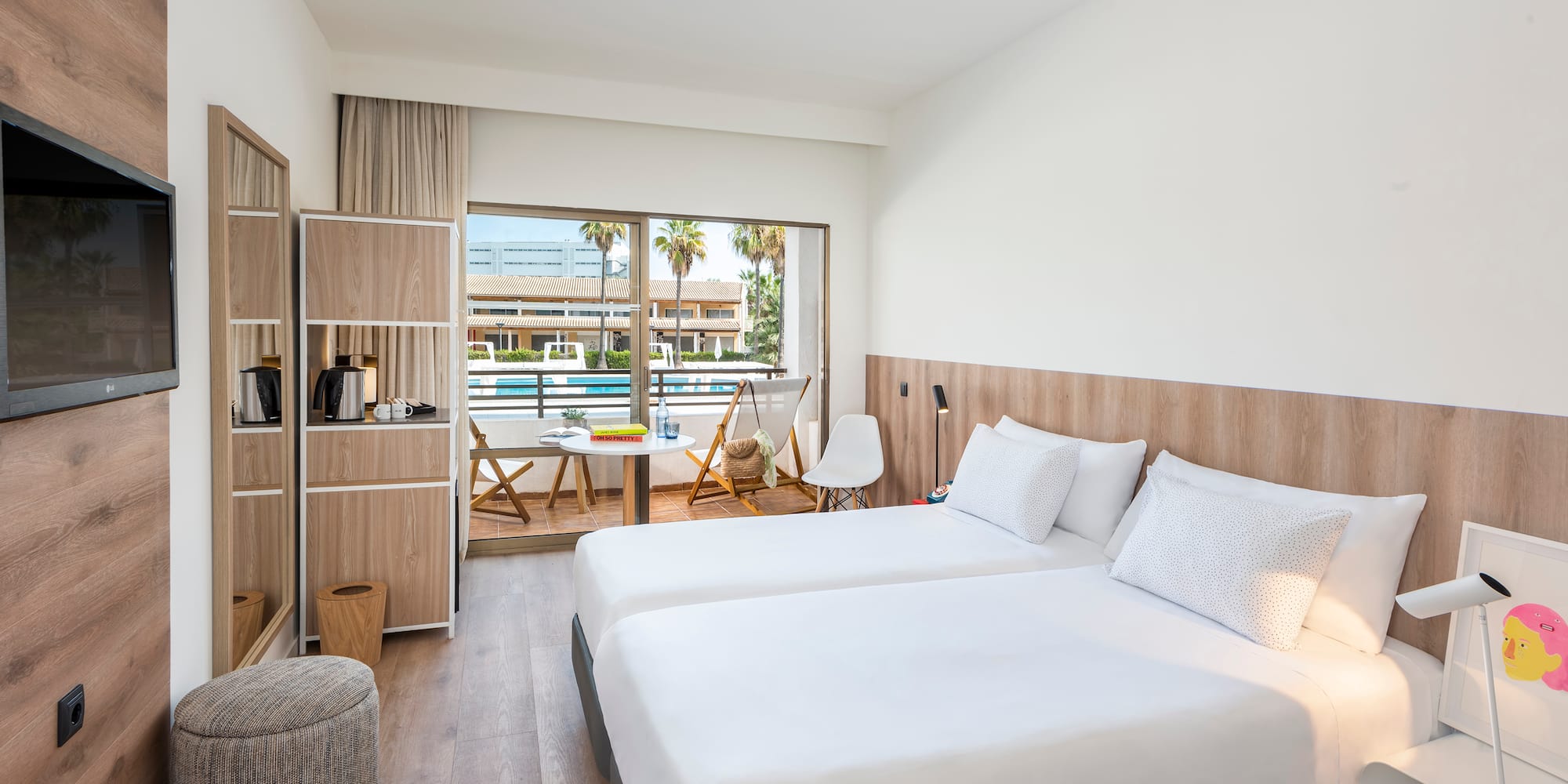 Modern hotel room with twin beds, private balcony, and pool view.