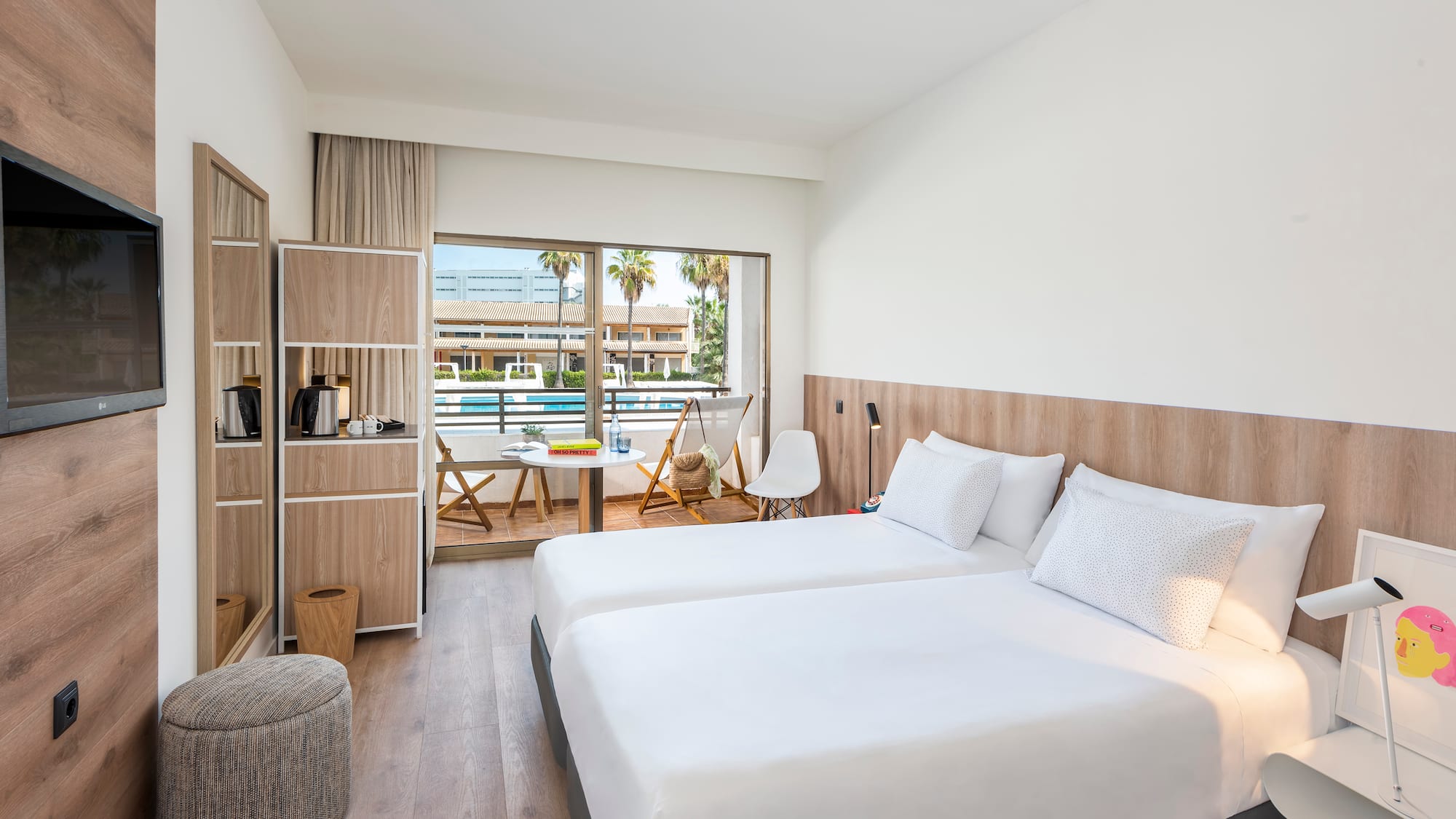 Modern hotel room with twin beds, private balcony, and pool view.