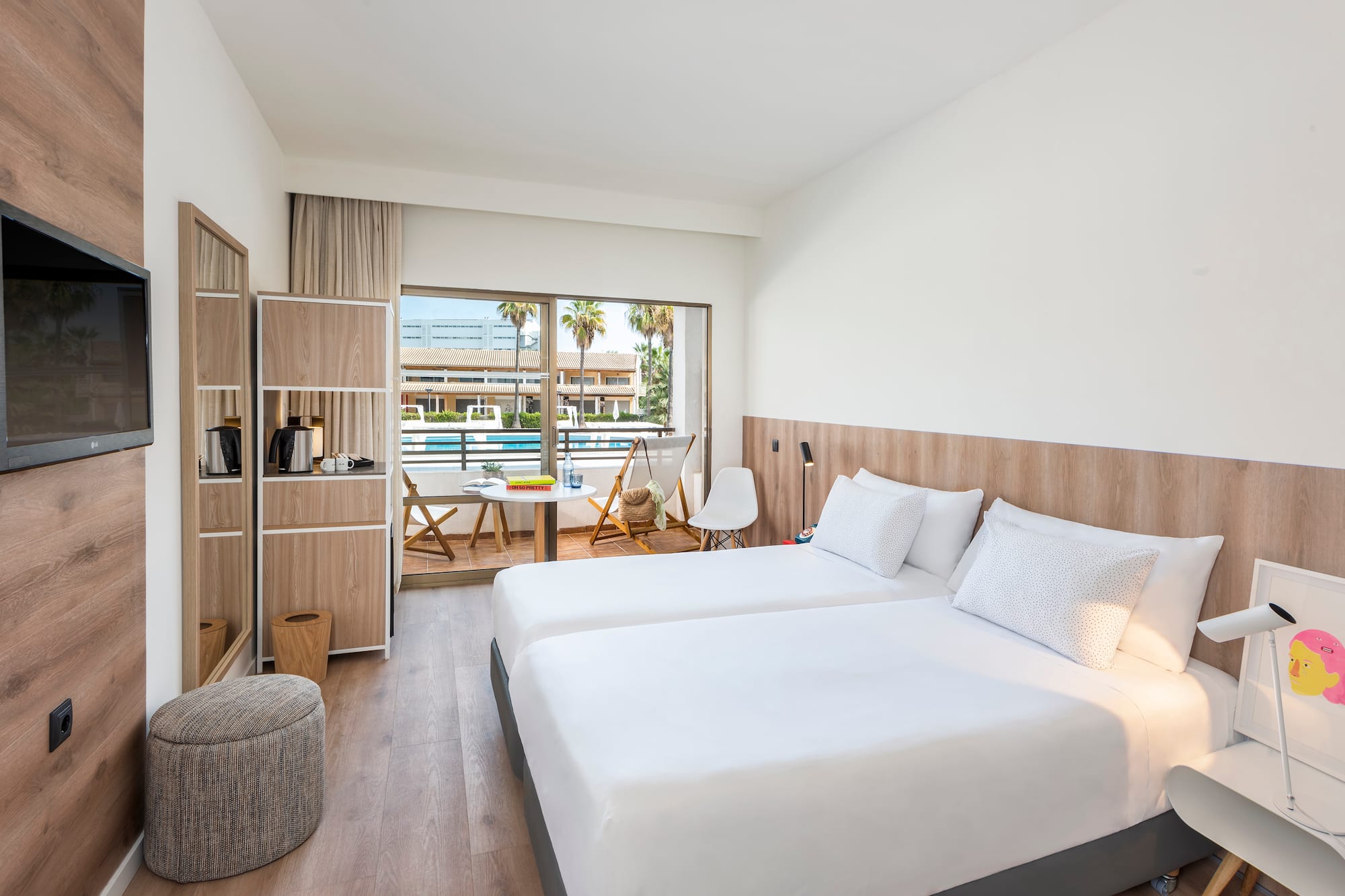 Modern hotel room with twin beds, private balcony, and pool view.