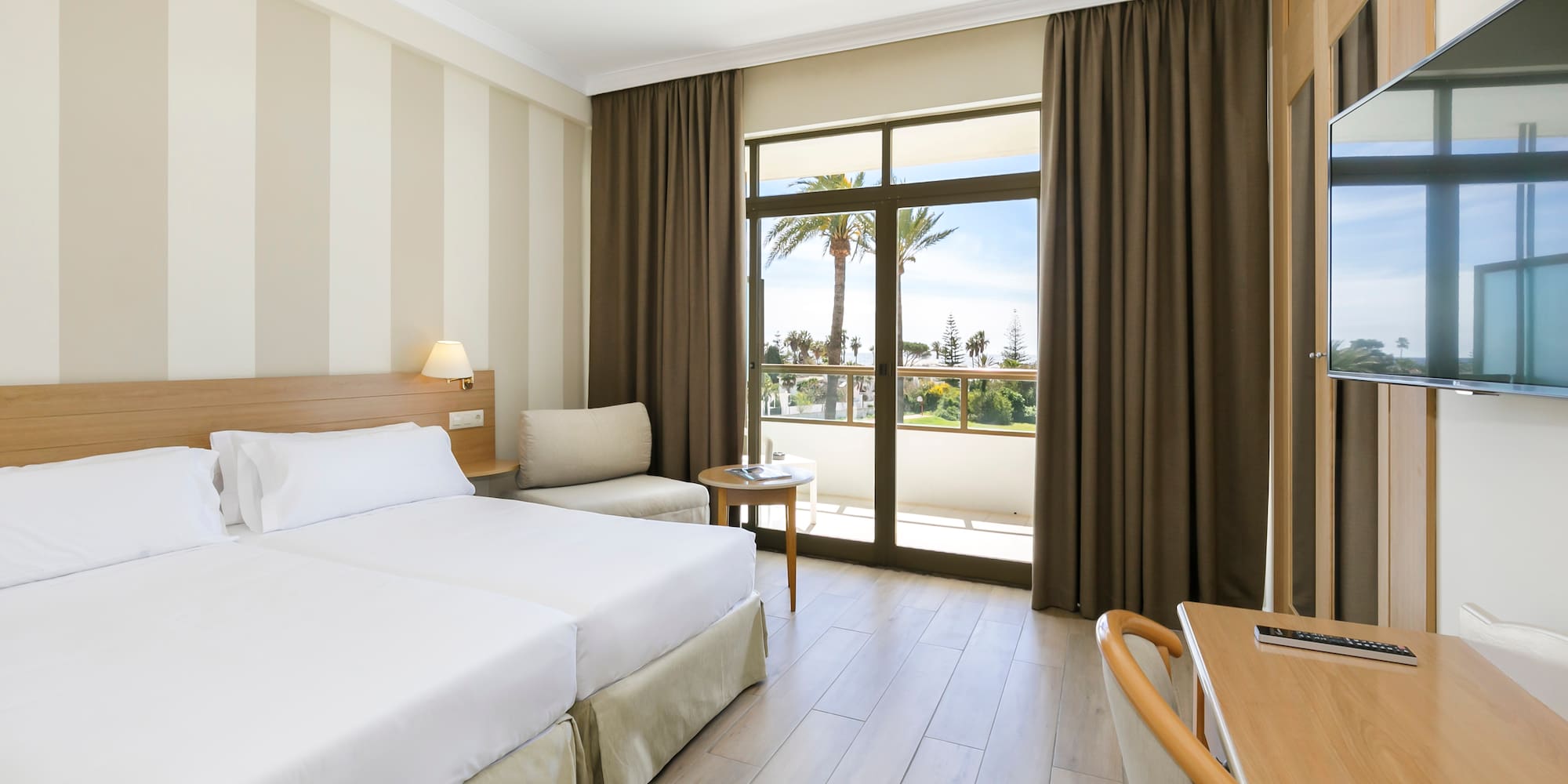 a room with two beds and a table and chairs