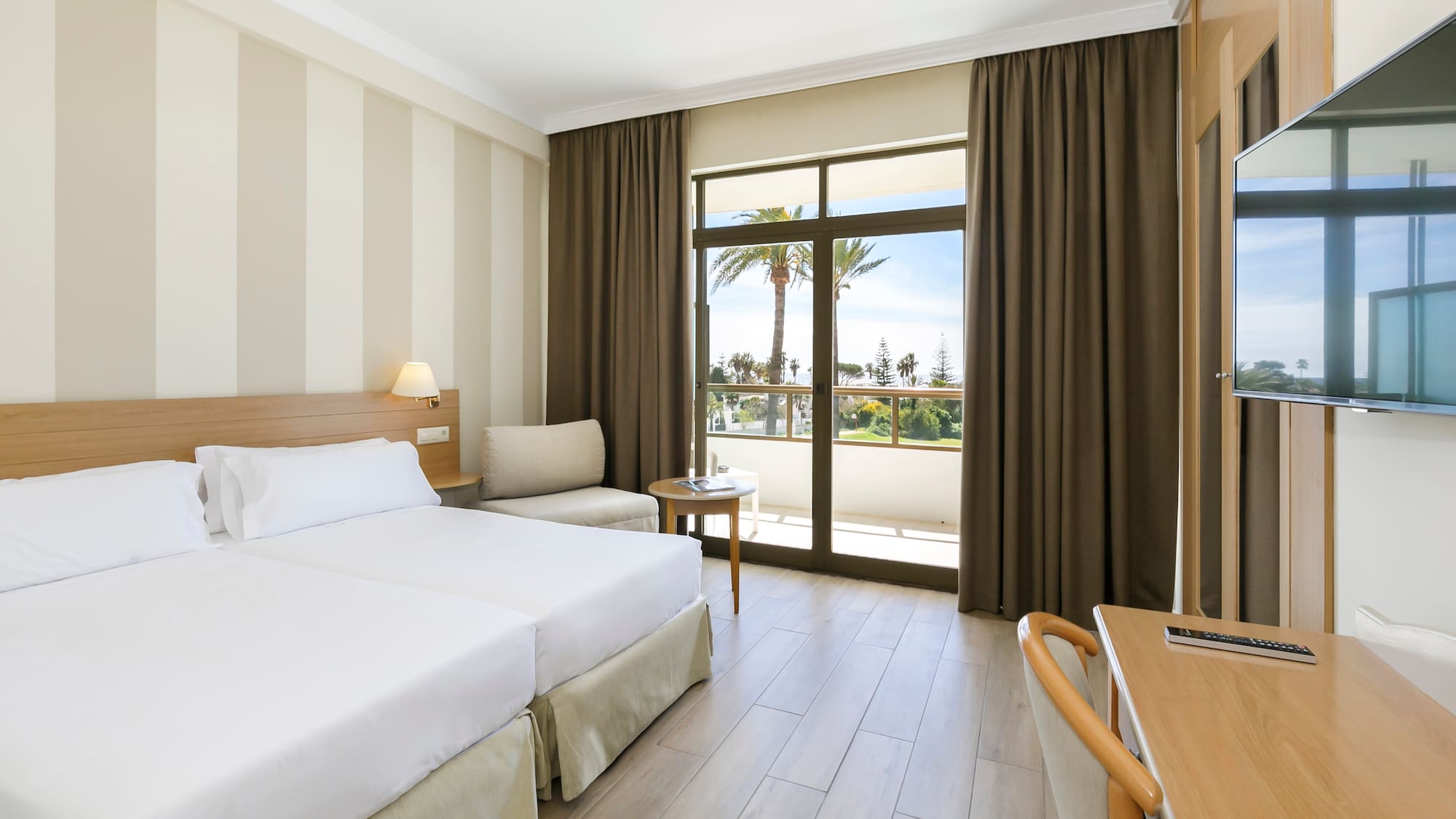 a room with two beds and a table and chairs