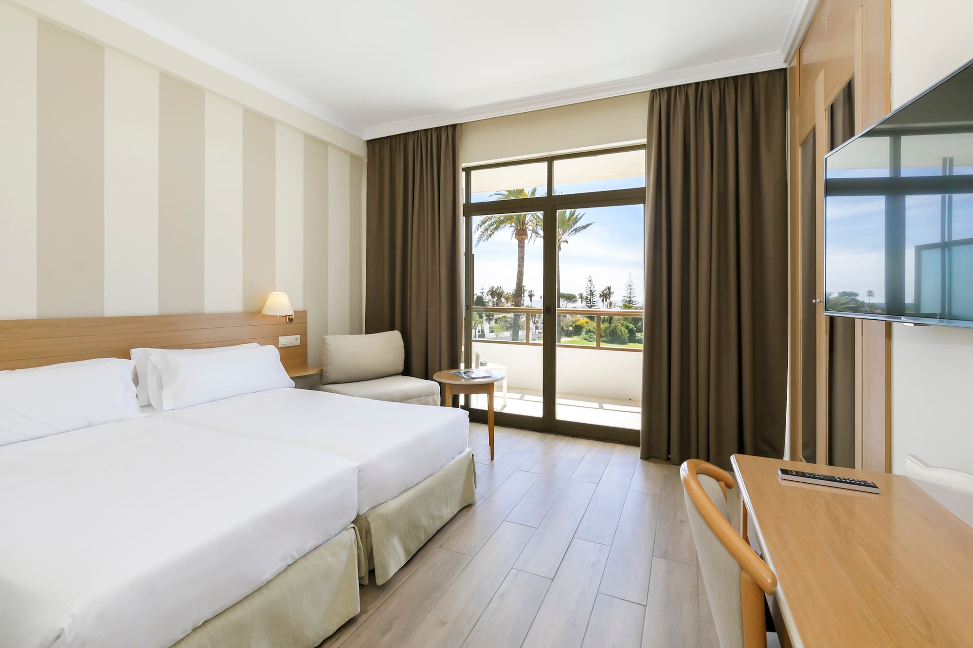 a room with two beds and a table and chairs