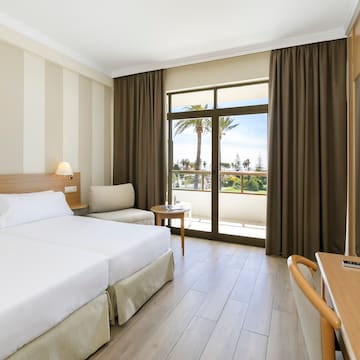 a room with two beds and a table and chairs