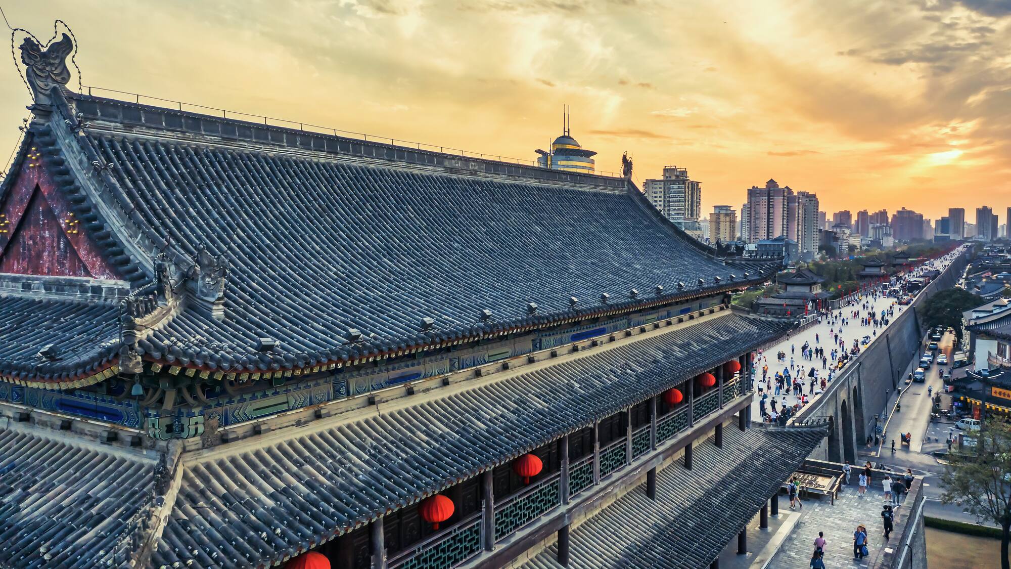 a building with a large roof and people walking on the sidewalk