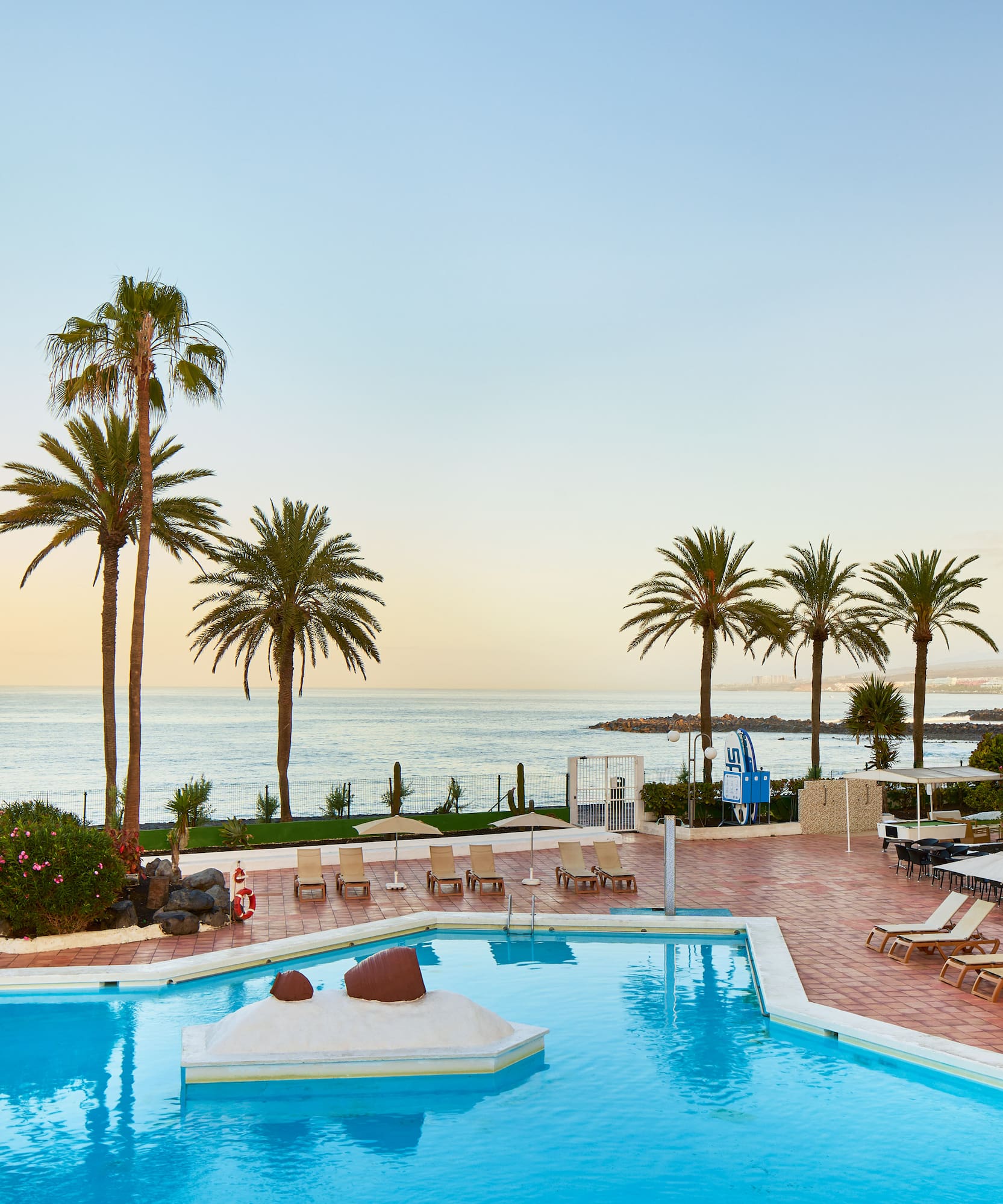 a pool with lounge chairs and palm trees