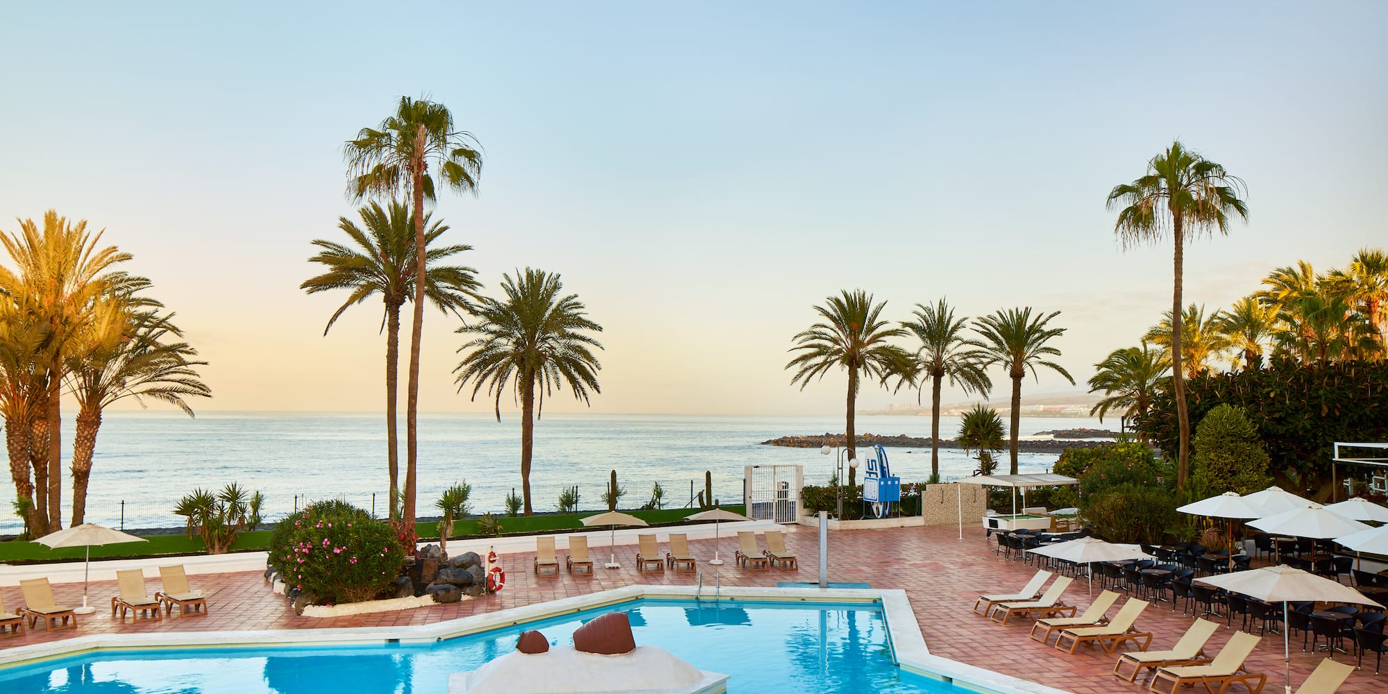 a pool with lounge chairs and palm trees