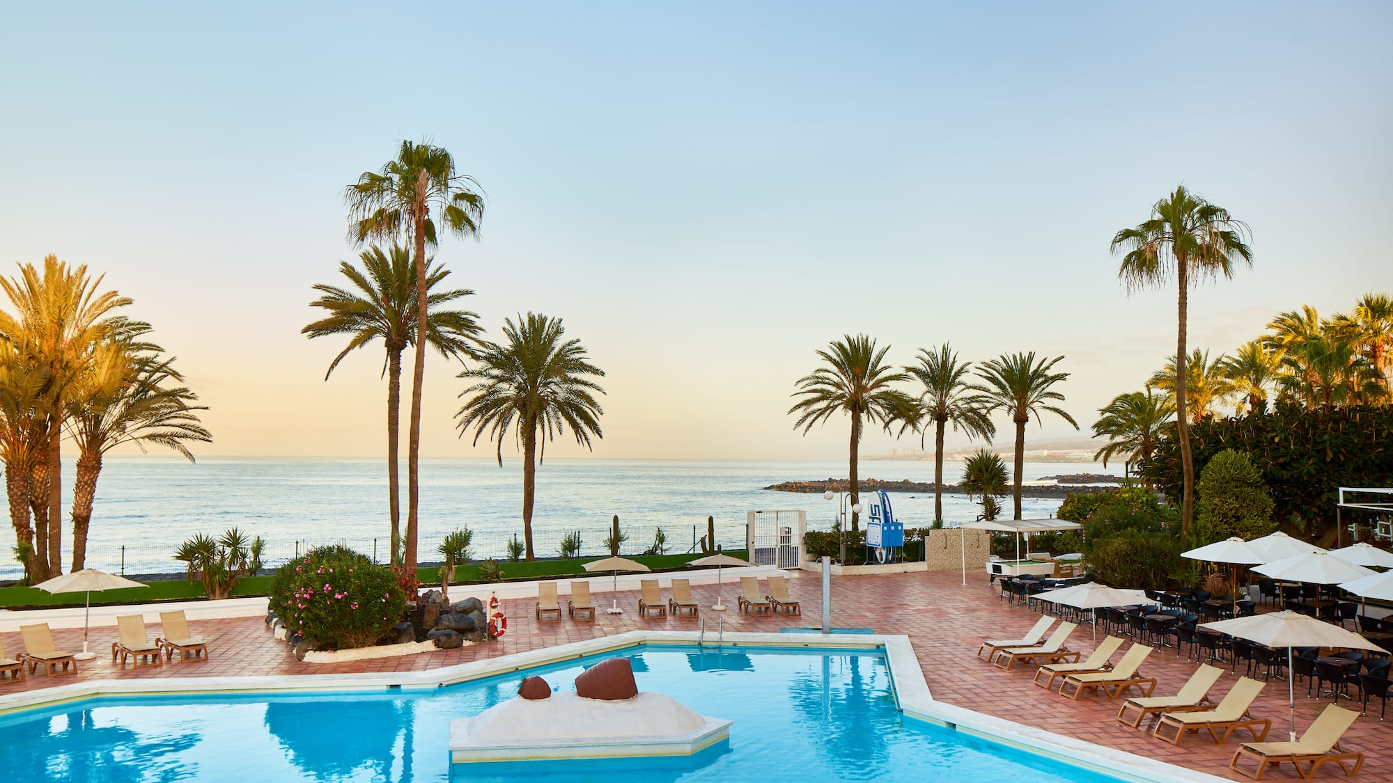 a pool with lounge chairs and palm trees