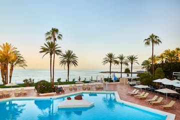 a pool with lounge chairs and palm trees