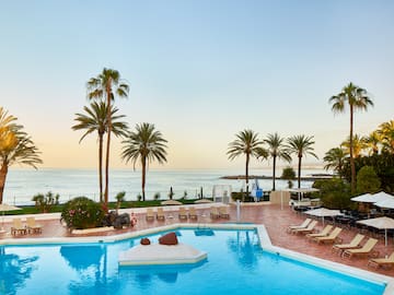 a pool with lounge chairs and palm trees