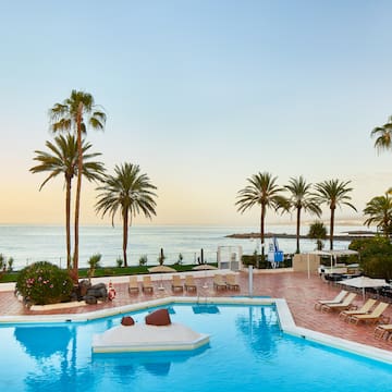 a pool with lounge chairs and palm trees