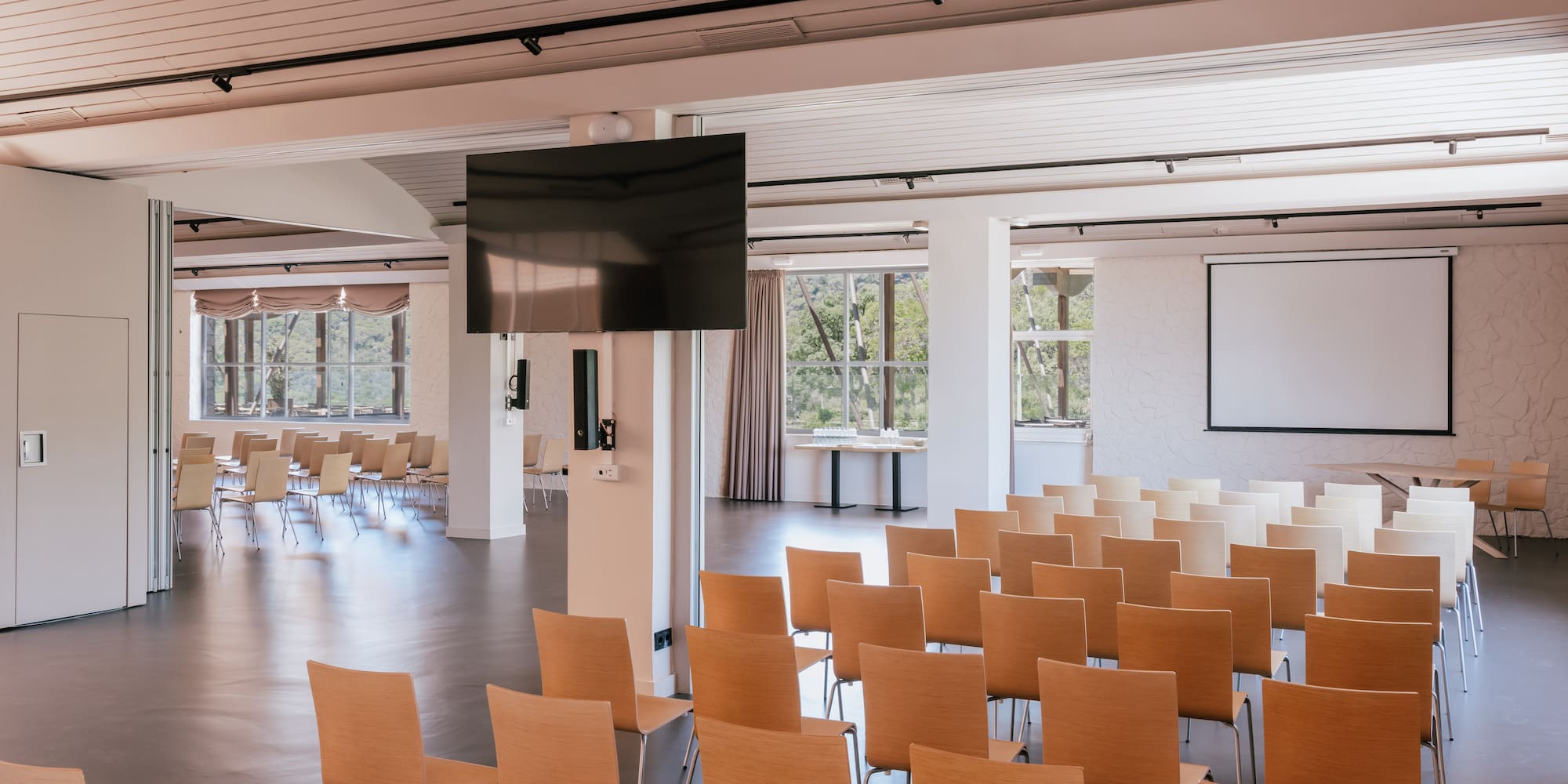 a room with many chairs and a screen