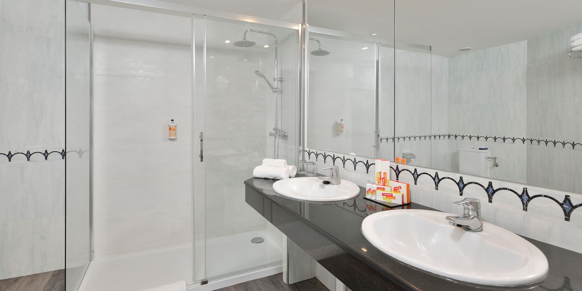 a bathroom with a shower and two sinks