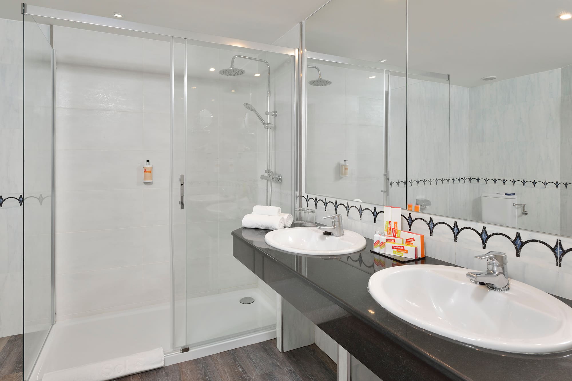 a bathroom with a shower and two sinks