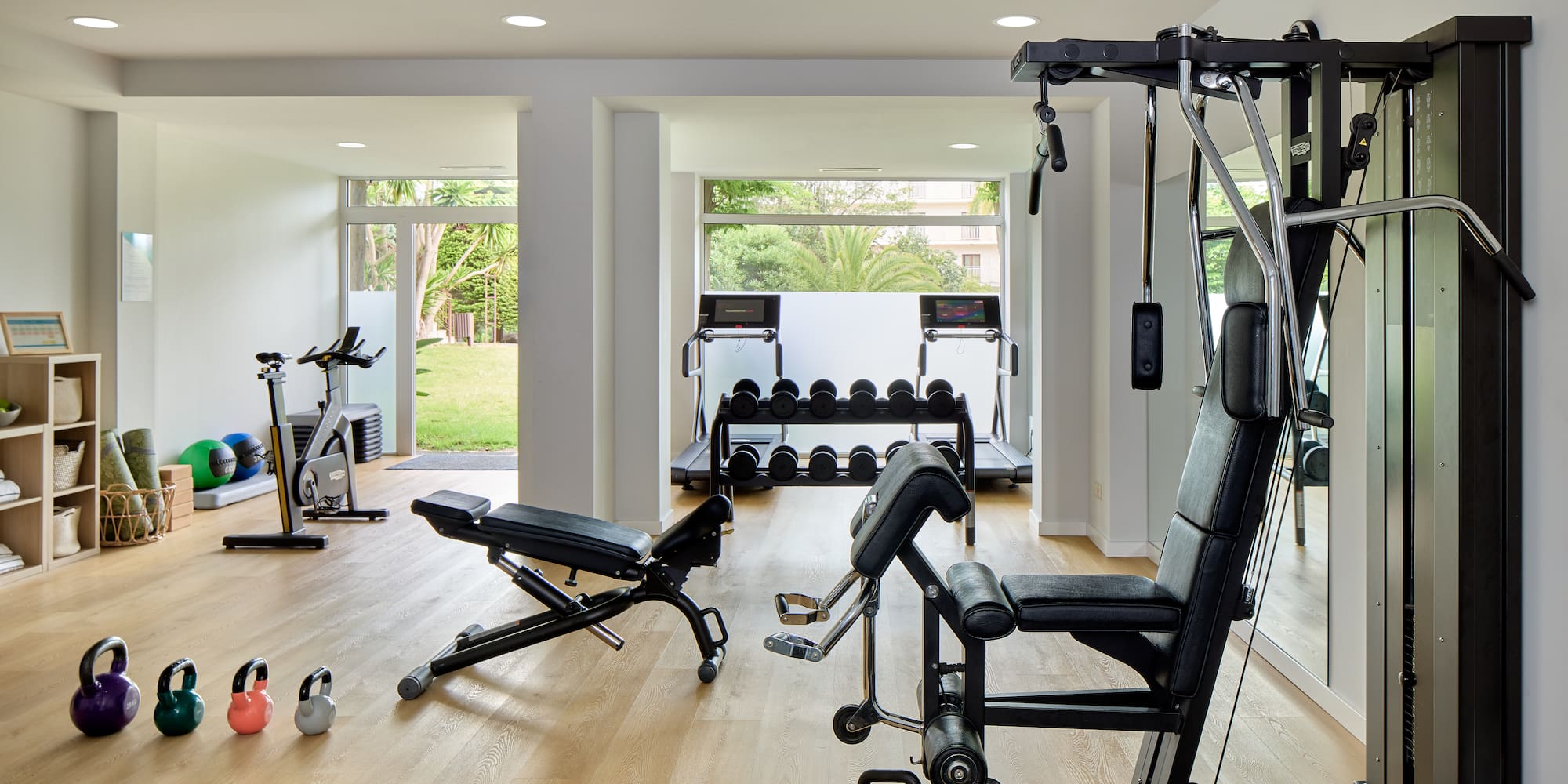 a room with exercise equipment and a large window.