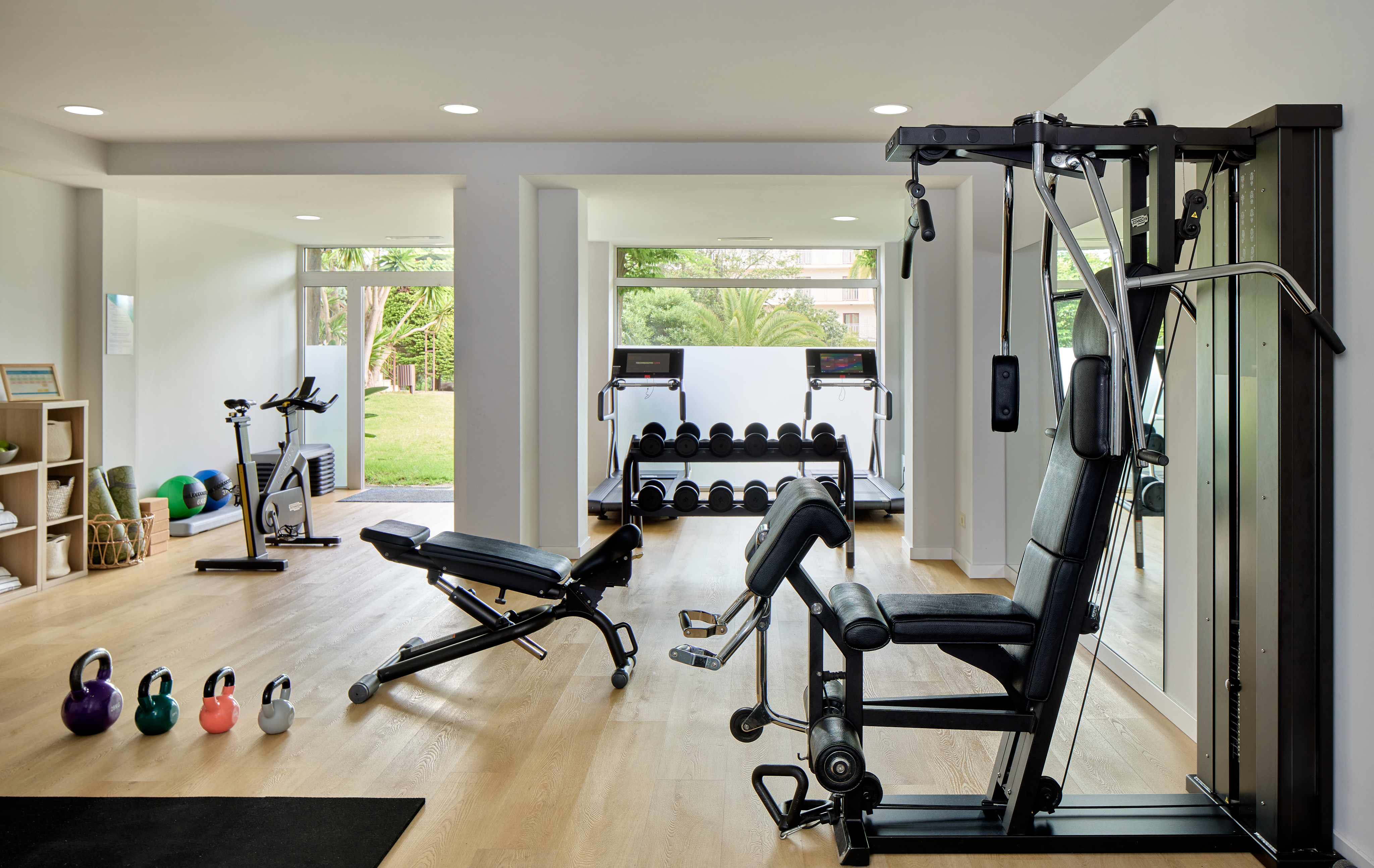 a room with exercise equipment and a large window.