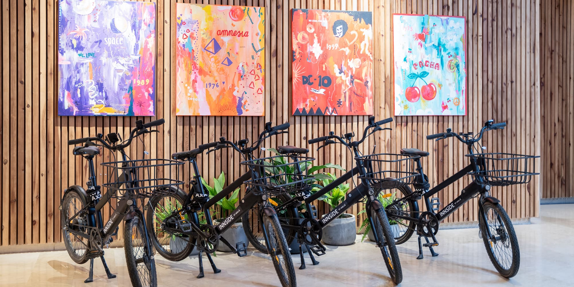 a group of bicycles in a room with paintings on the wall