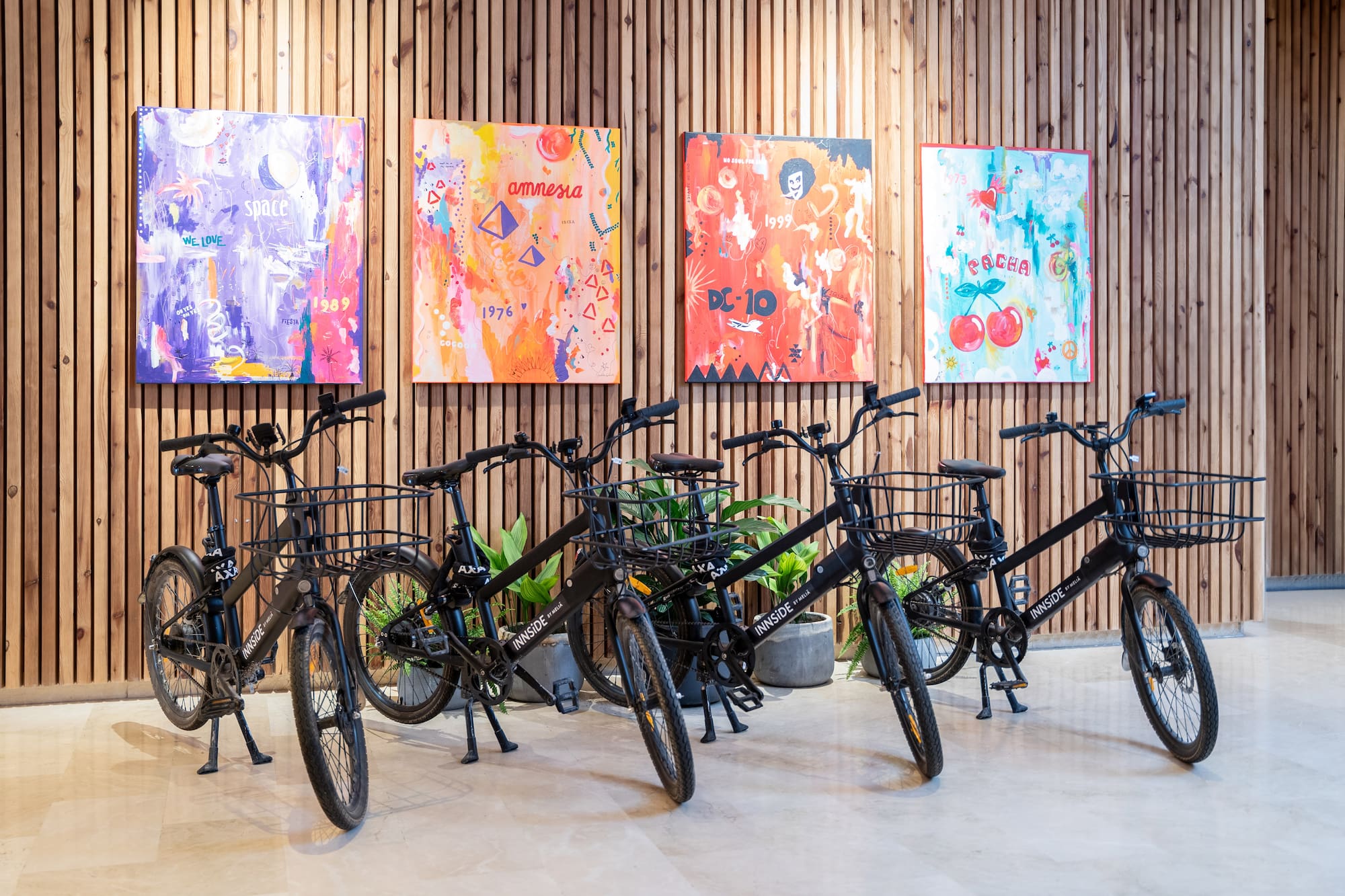 a group of bicycles in a room with paintings on the wall