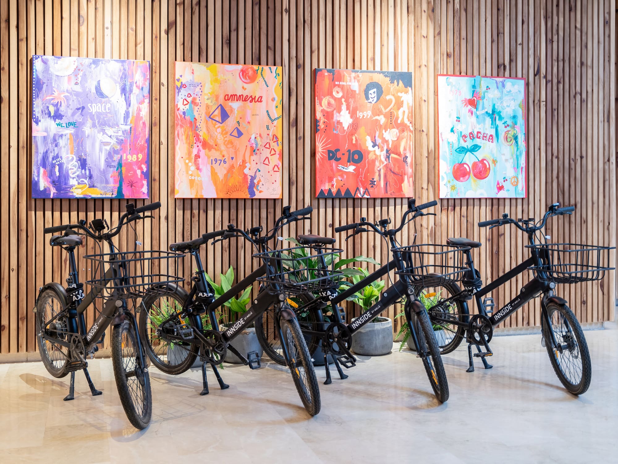 a group of bicycles in a room with paintings on the wall