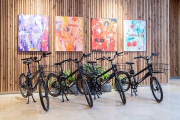 a group of bicycles in a room with paintings on the wall