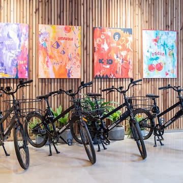 a group of bicycles in a room with paintings on the wall