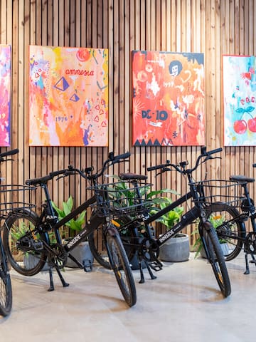 a group of bicycles in a room with paintings on the wall