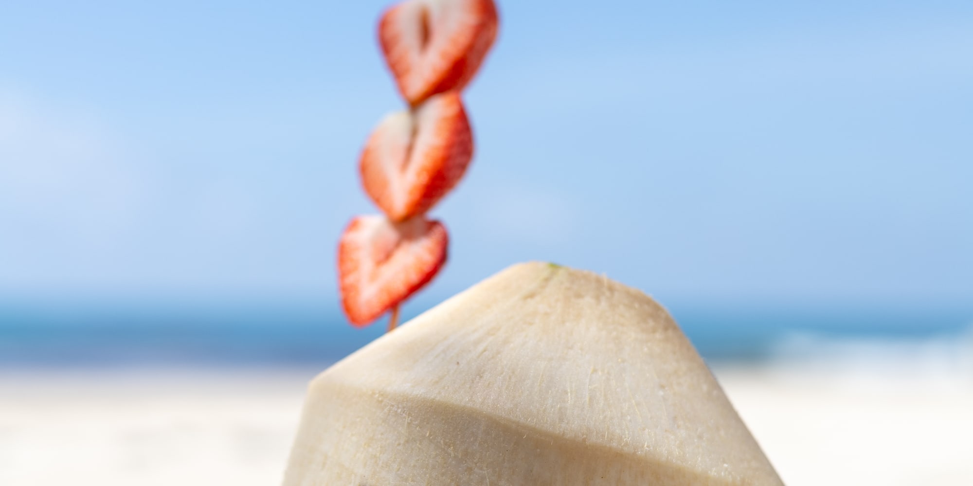 Paradisus by Melia branded coconut drink with strawberries on a beach.