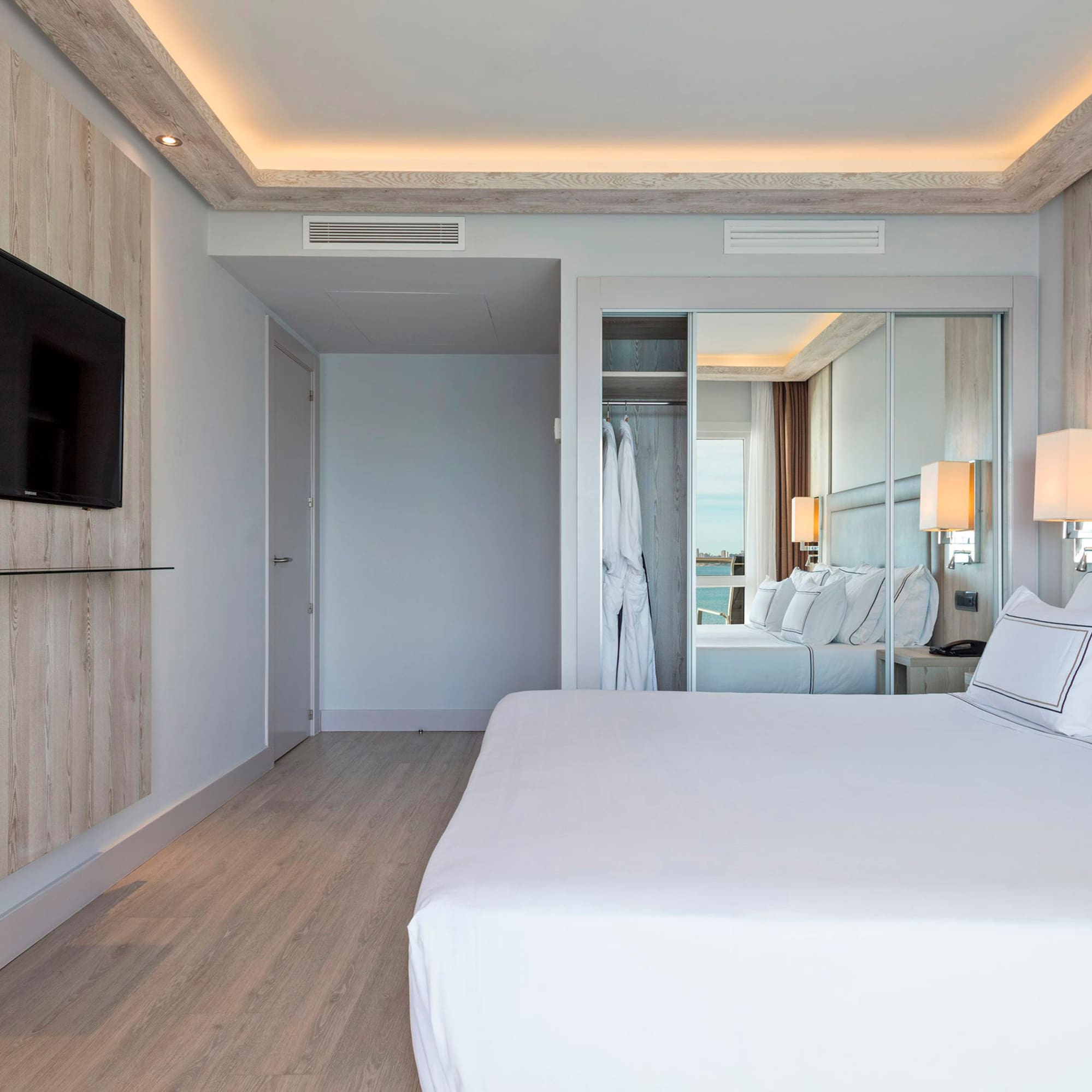 a bedroom with a large bed and a mirror