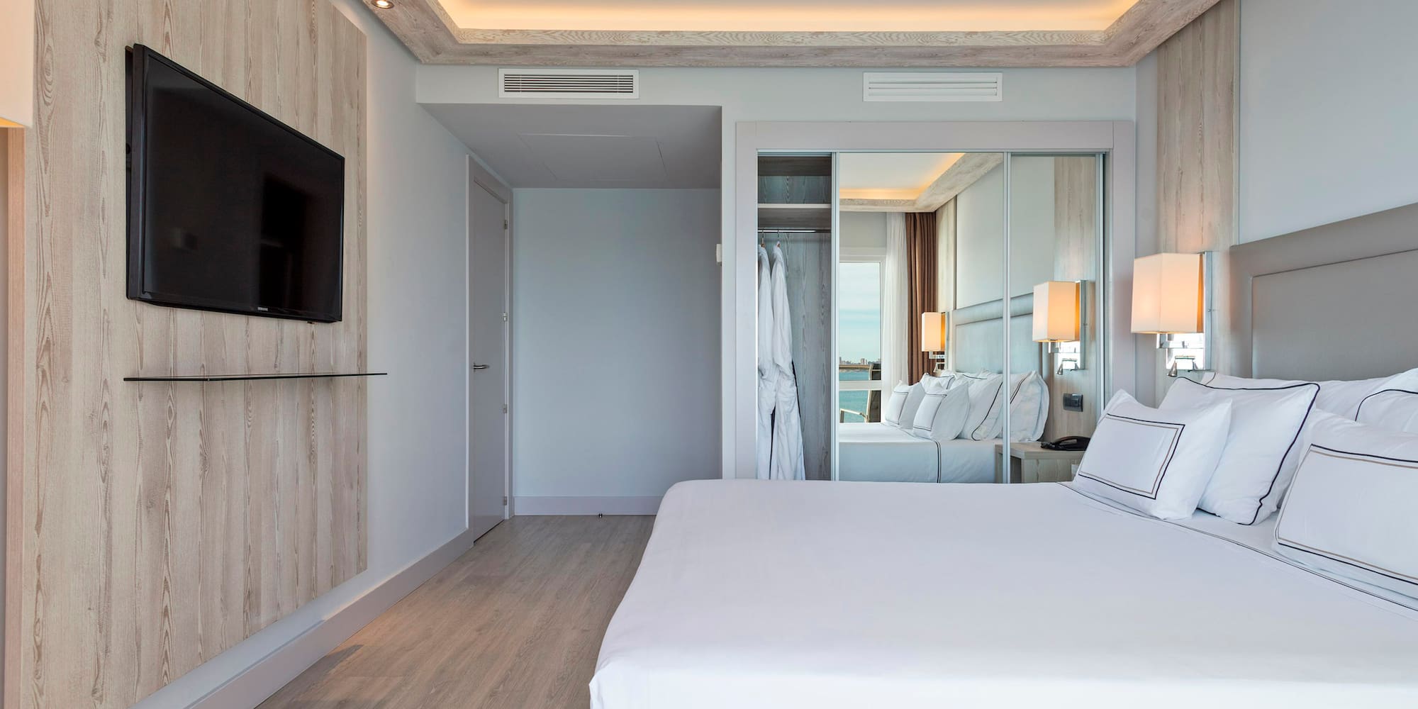 a bedroom with a large bed and a mirror