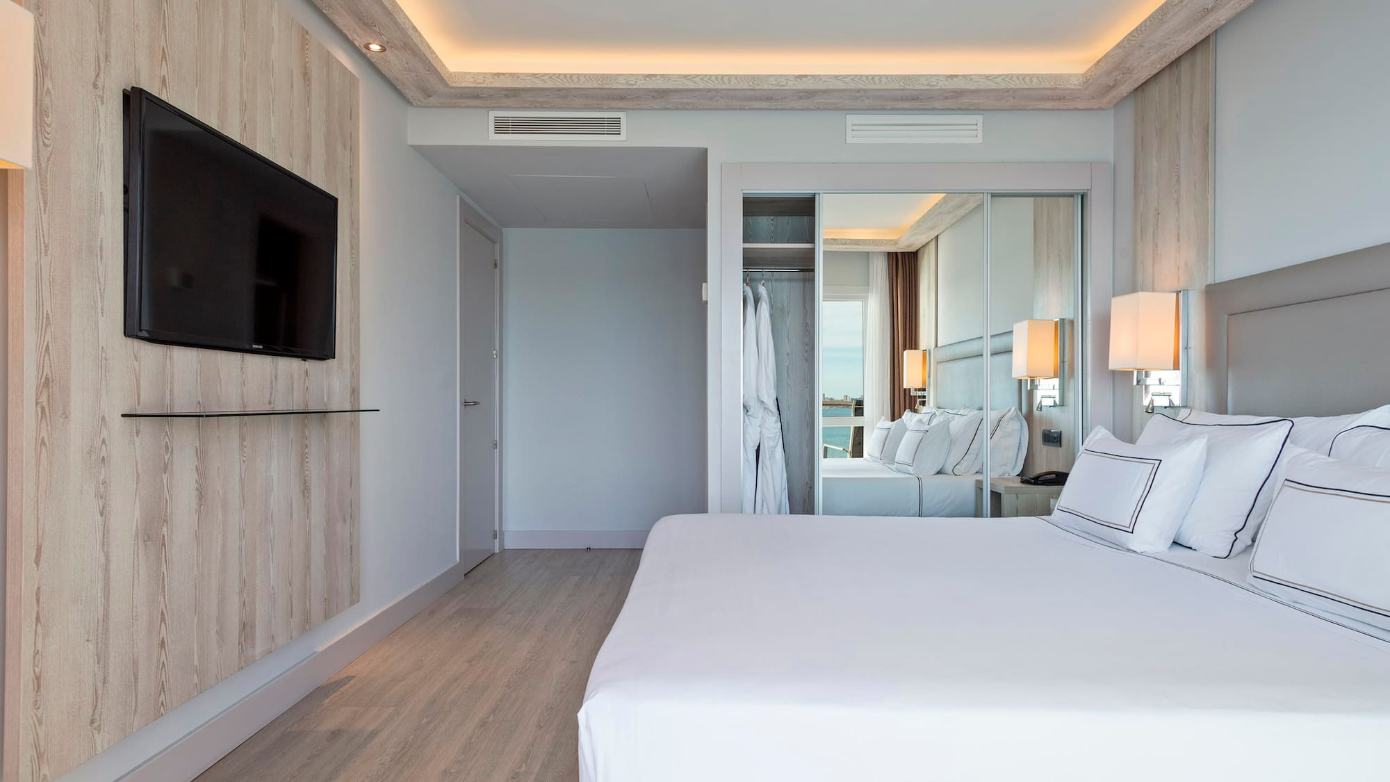 a bedroom with a large bed and a mirror