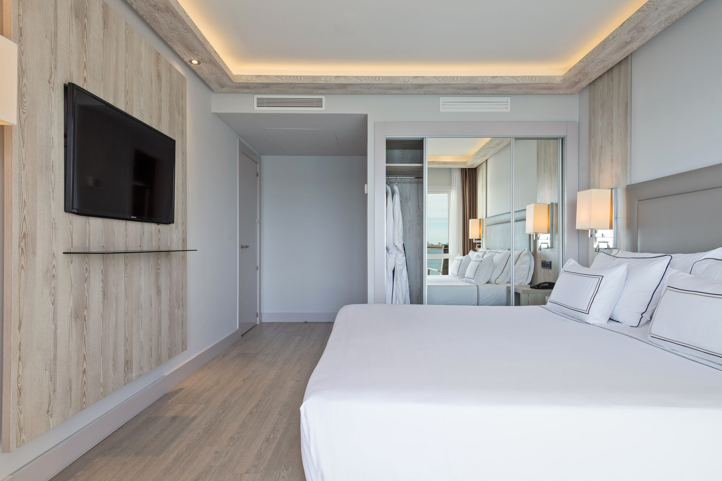 a bedroom with a large bed and a mirror
