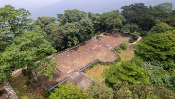 an aerial view of a stone building surrounded by trees