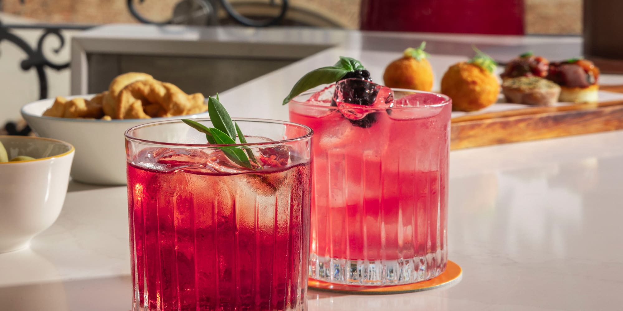 two glasses of pink drinks on a table