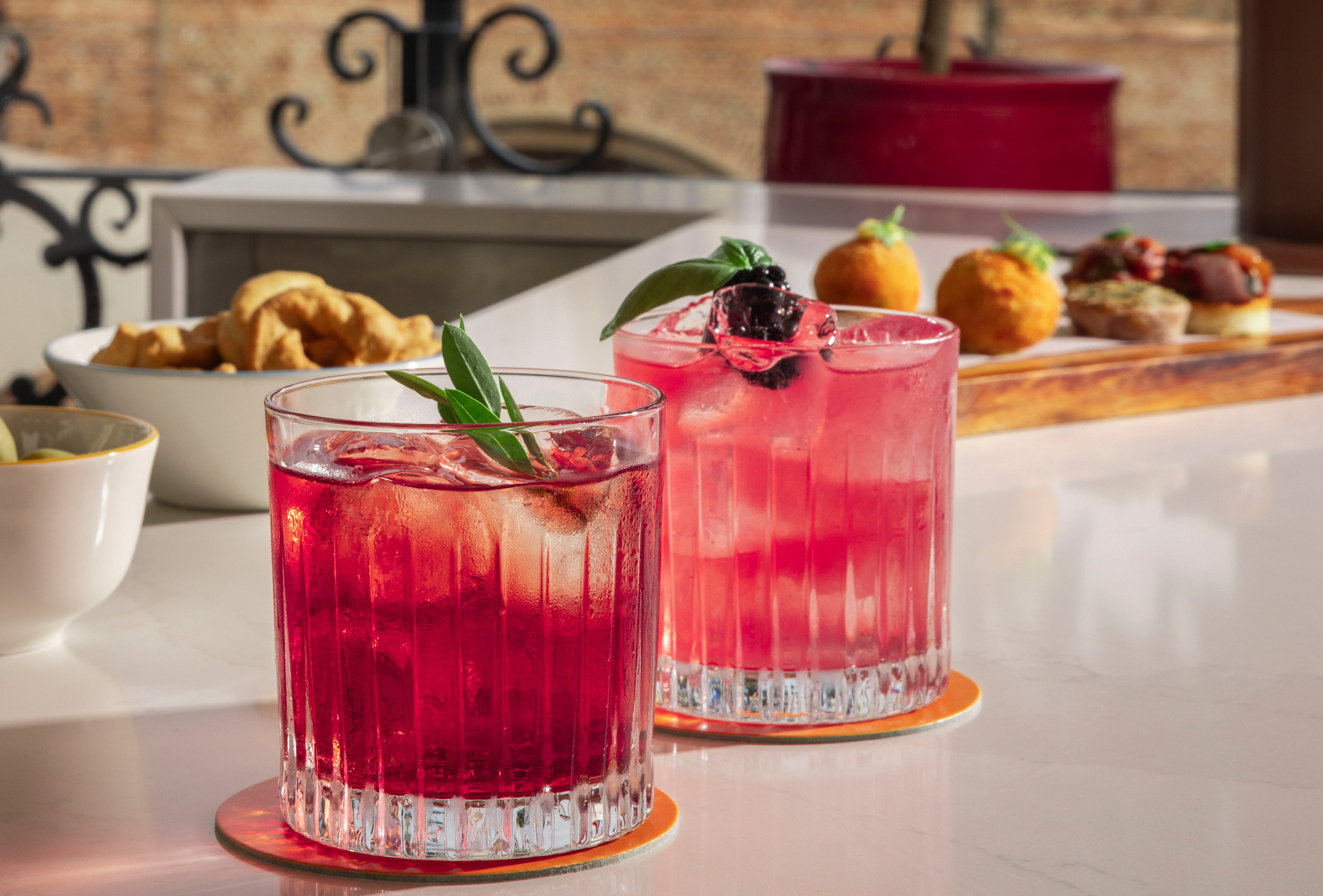 two glasses of pink drinks on a table