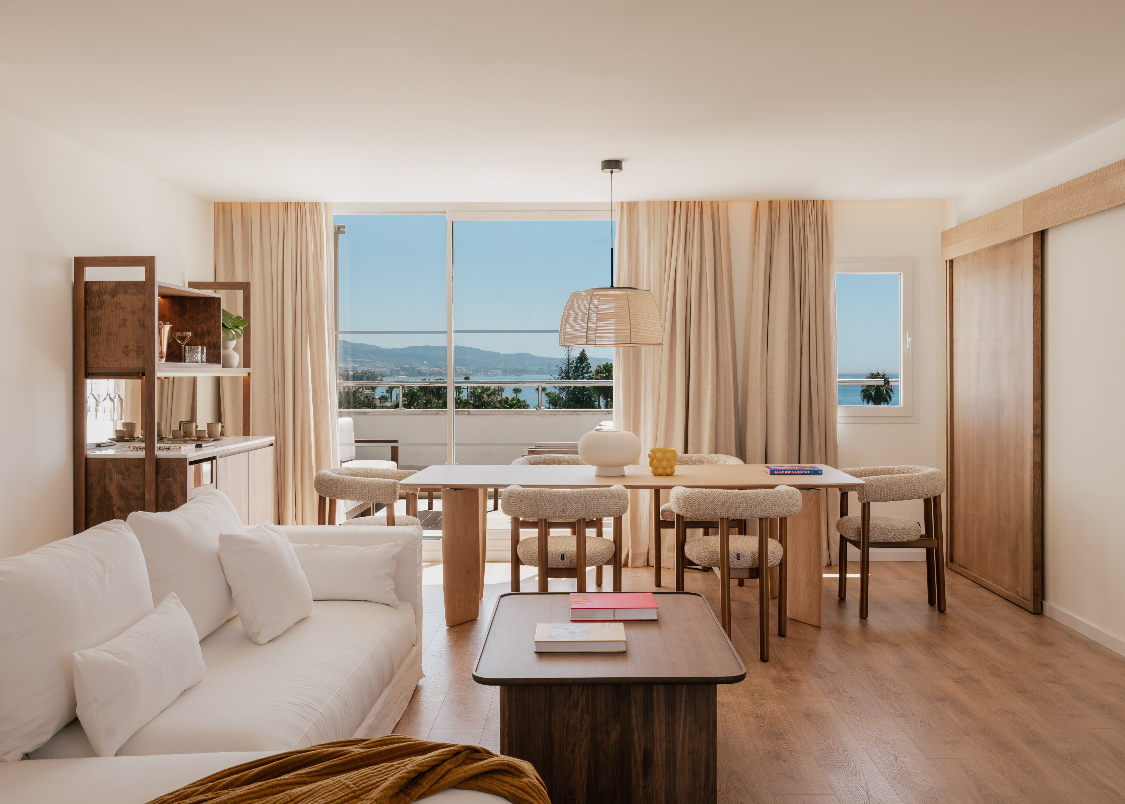 Modern open-plan living and dining room with stunning sea view balcony.
