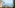 Coastal balcony view with palm trees, boats, and clear blue ocean.