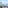 Coastal balcony view with palm trees, boats, and clear blue ocean.