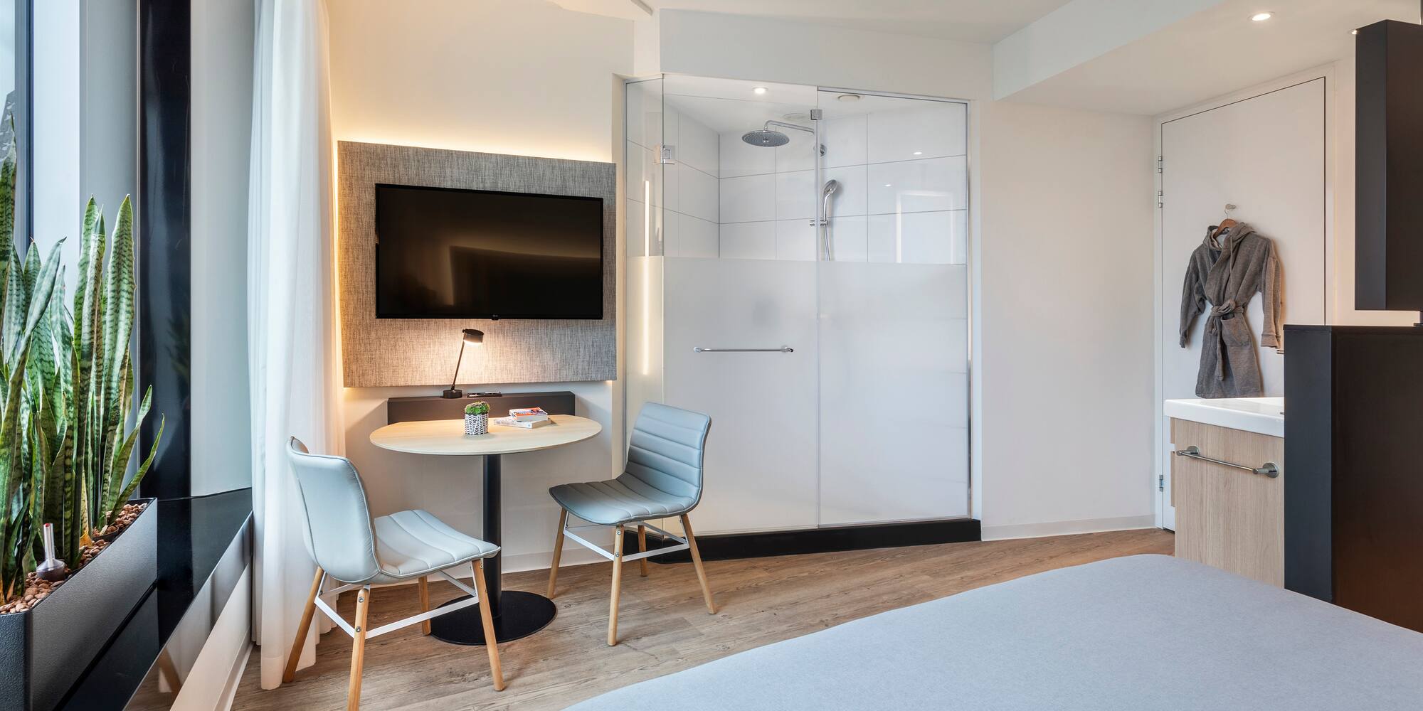 a room with a bed and a table and chairs