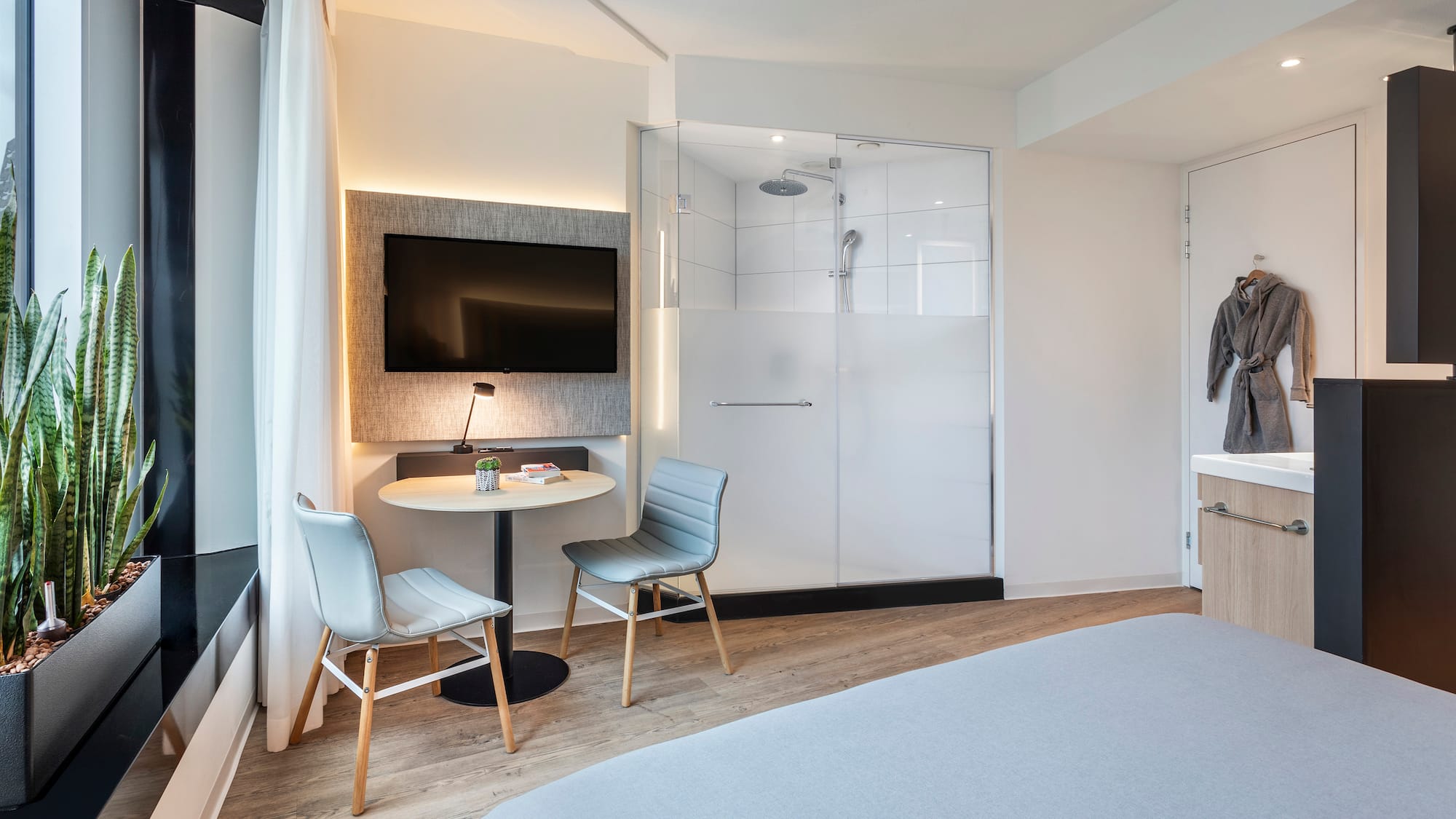 a room with a bed and a table and chairs