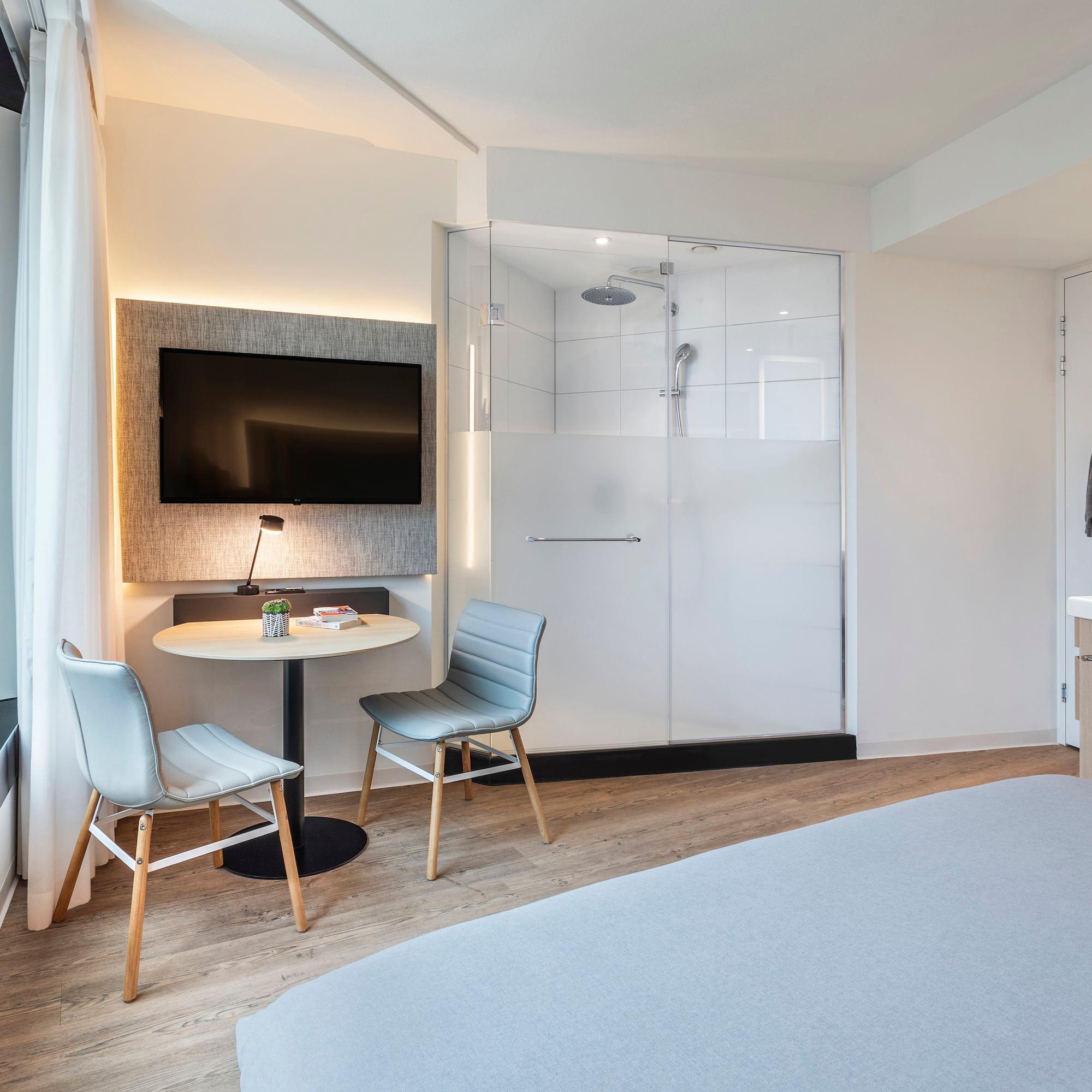 a room with a bed and a table and chairs