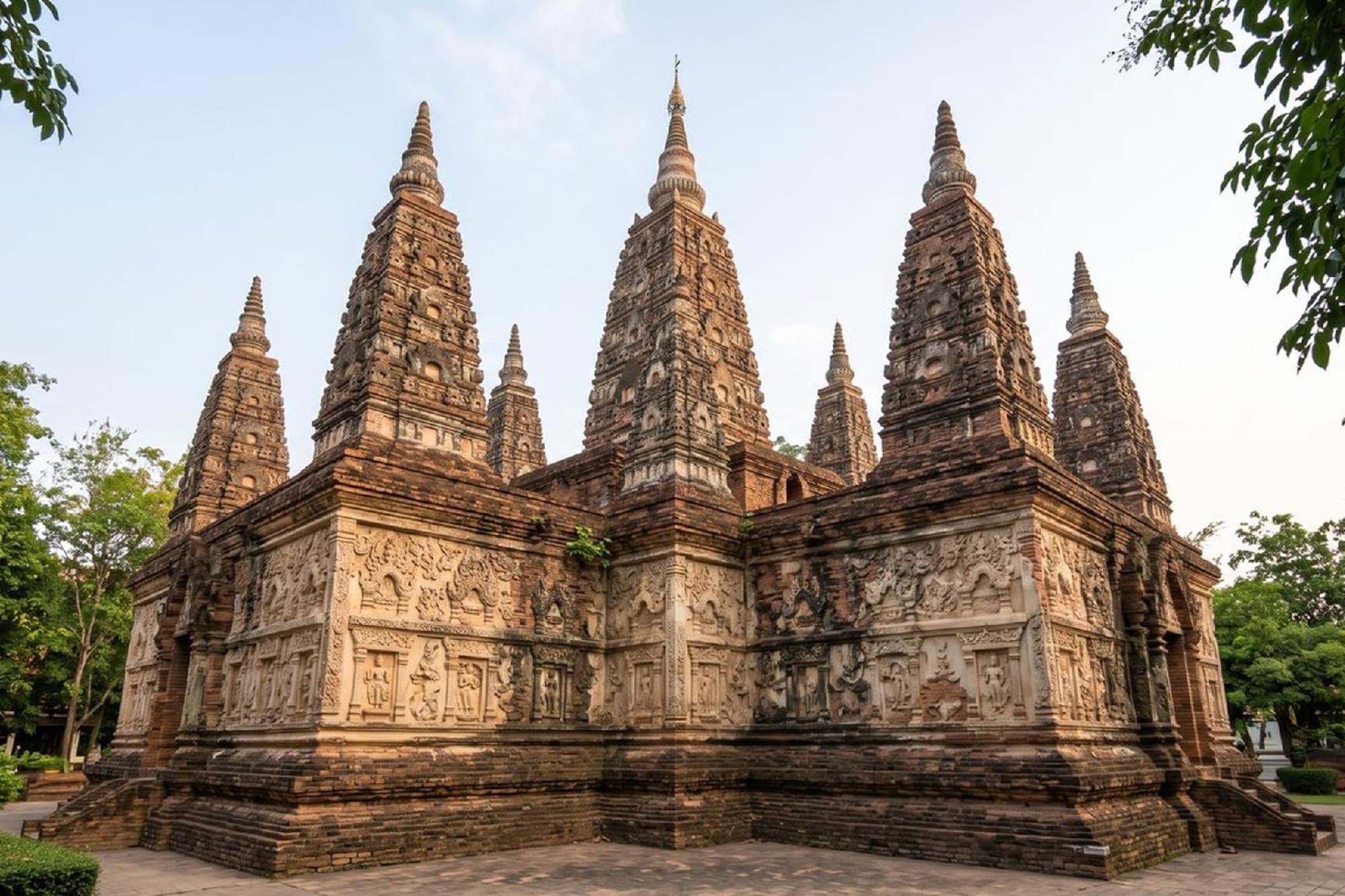 Brick Buddhist temple with multiple spires and intricate relief carvings.