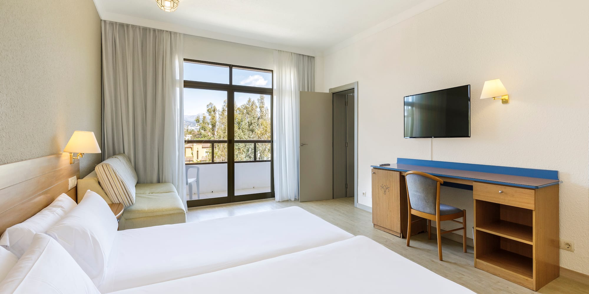 a room with two beds and a television