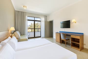 a room with two beds and a television