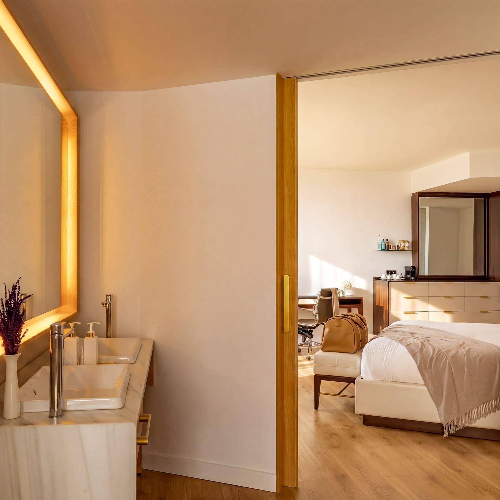 Modern hotel suite with double vanity bathroom and elegant bedroom.