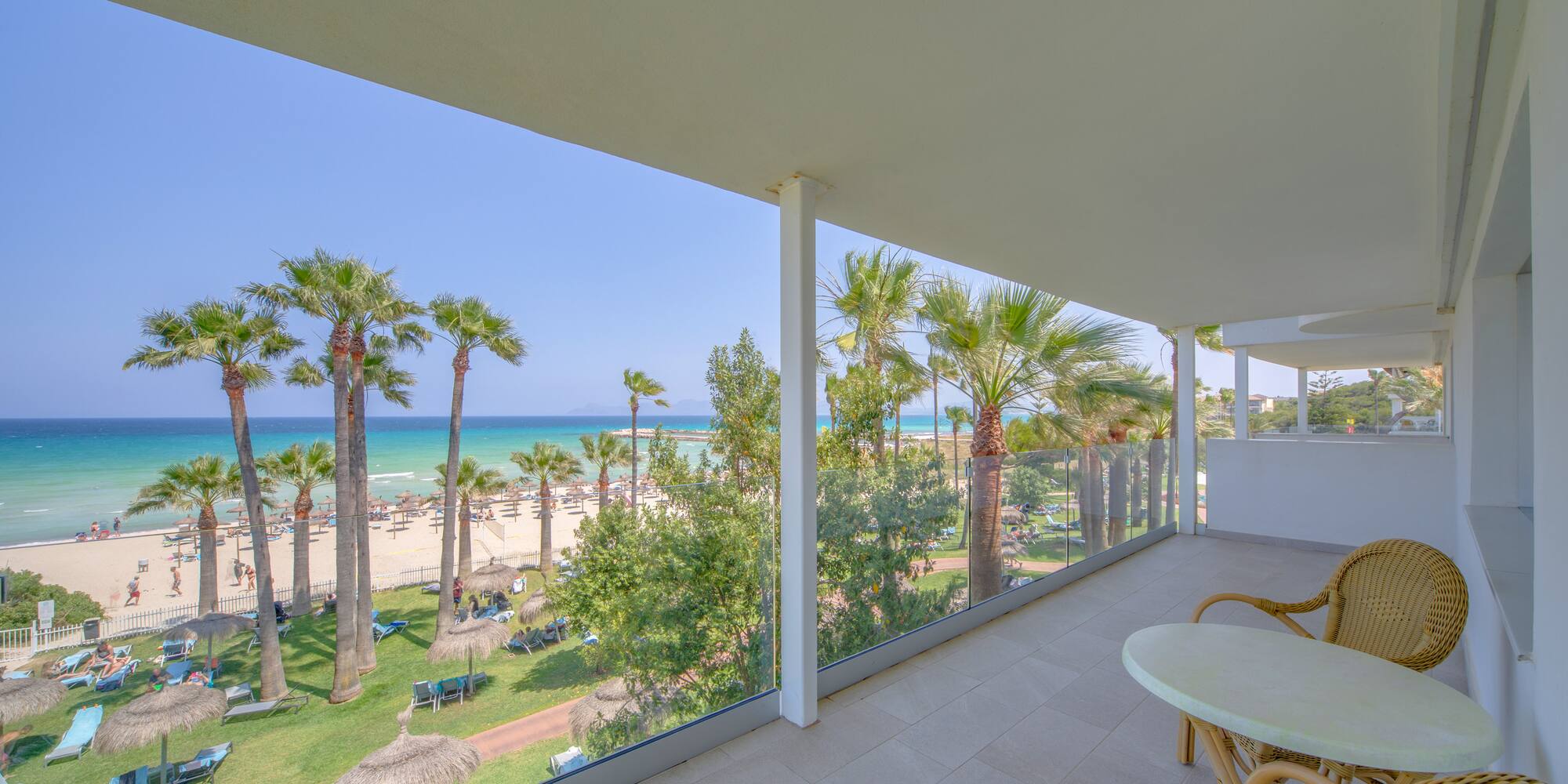 a balcony with a view of the beach and palm trees
