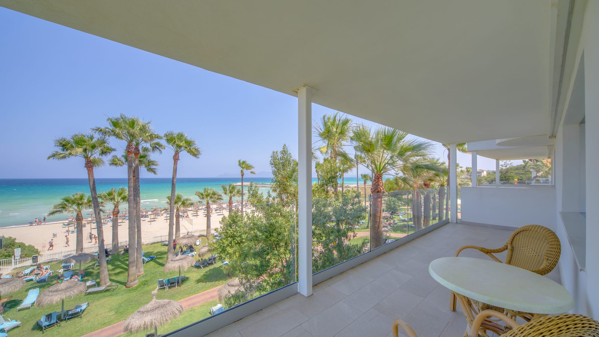 a balcony with a view of the beach and palm trees