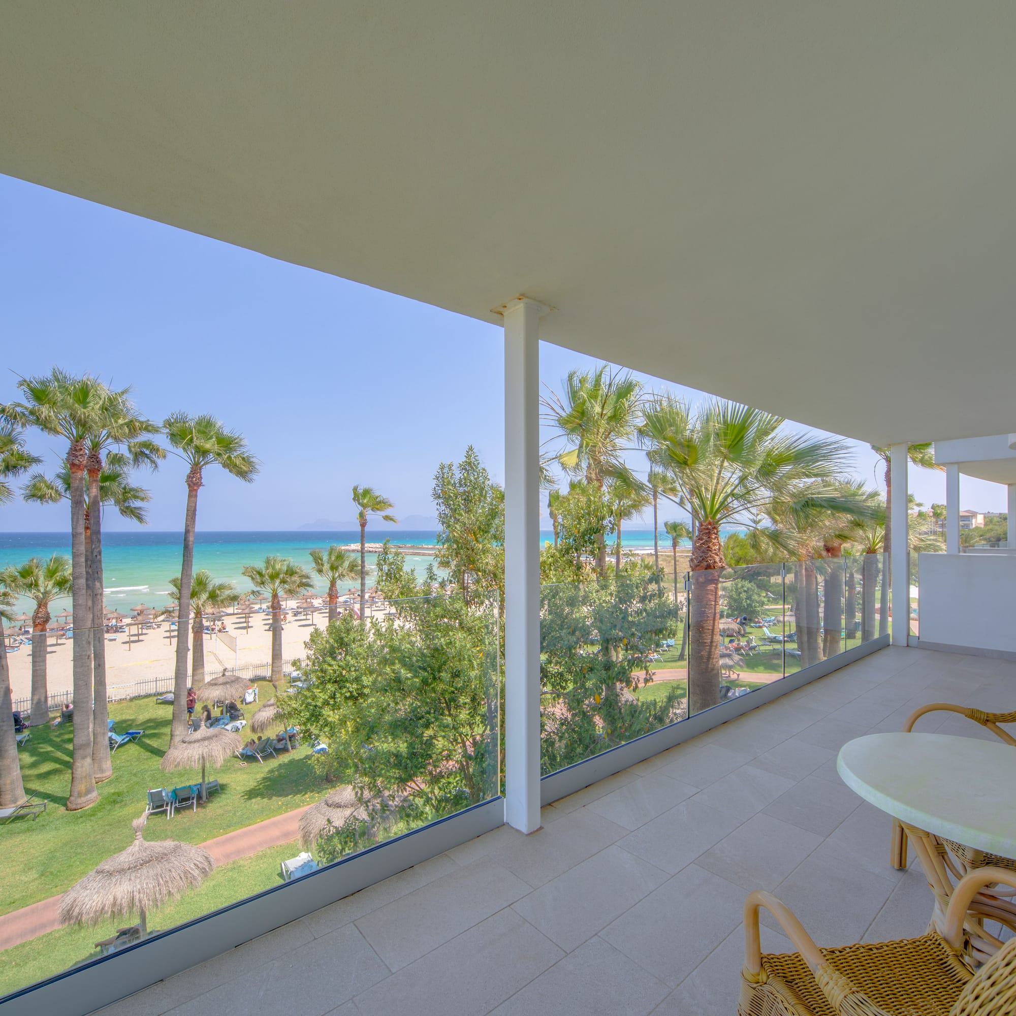 a balcony with a view of the beach and palm trees