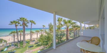 a balcony with a view of the beach and palm trees