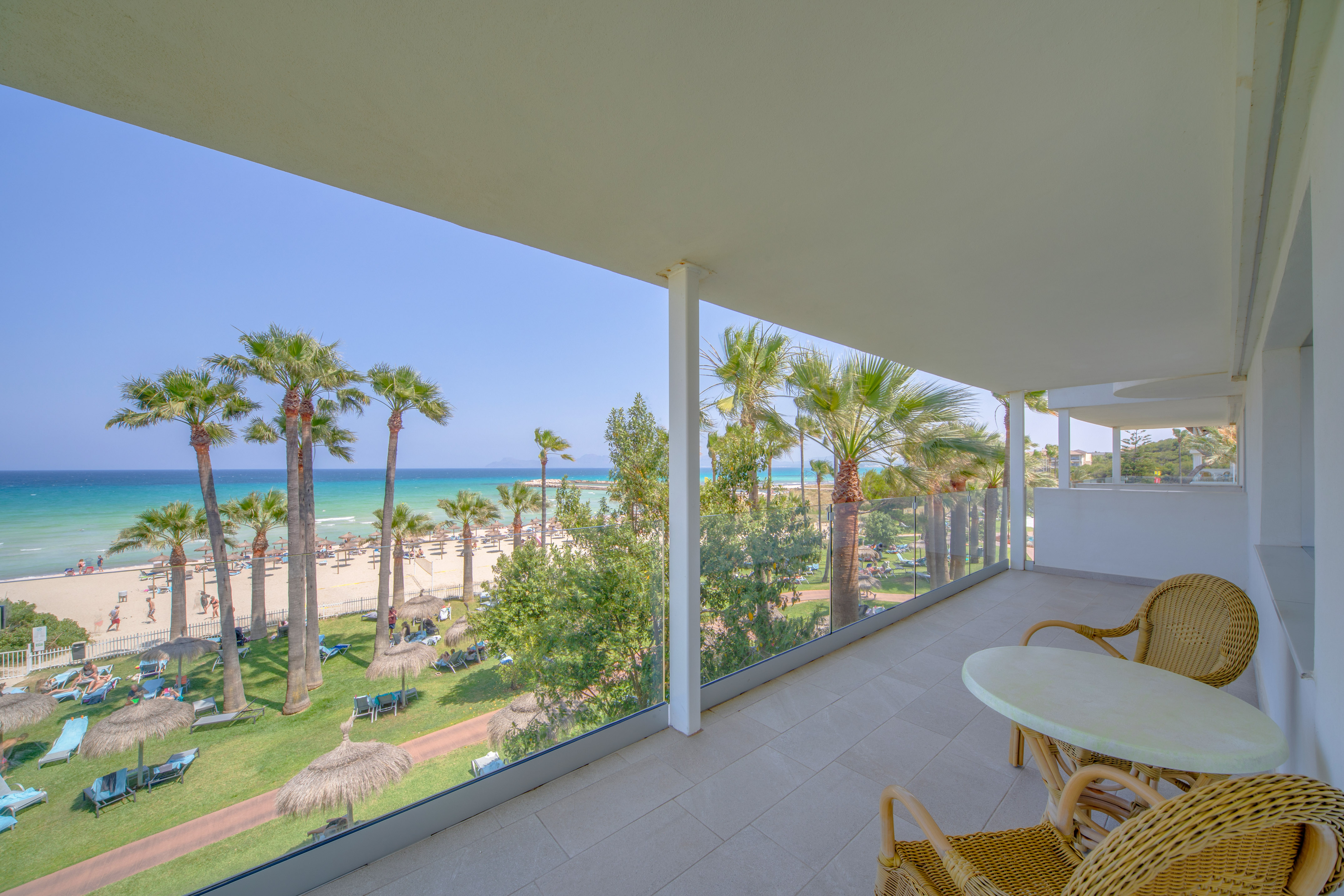 a balcony with a view of the beach and palm trees