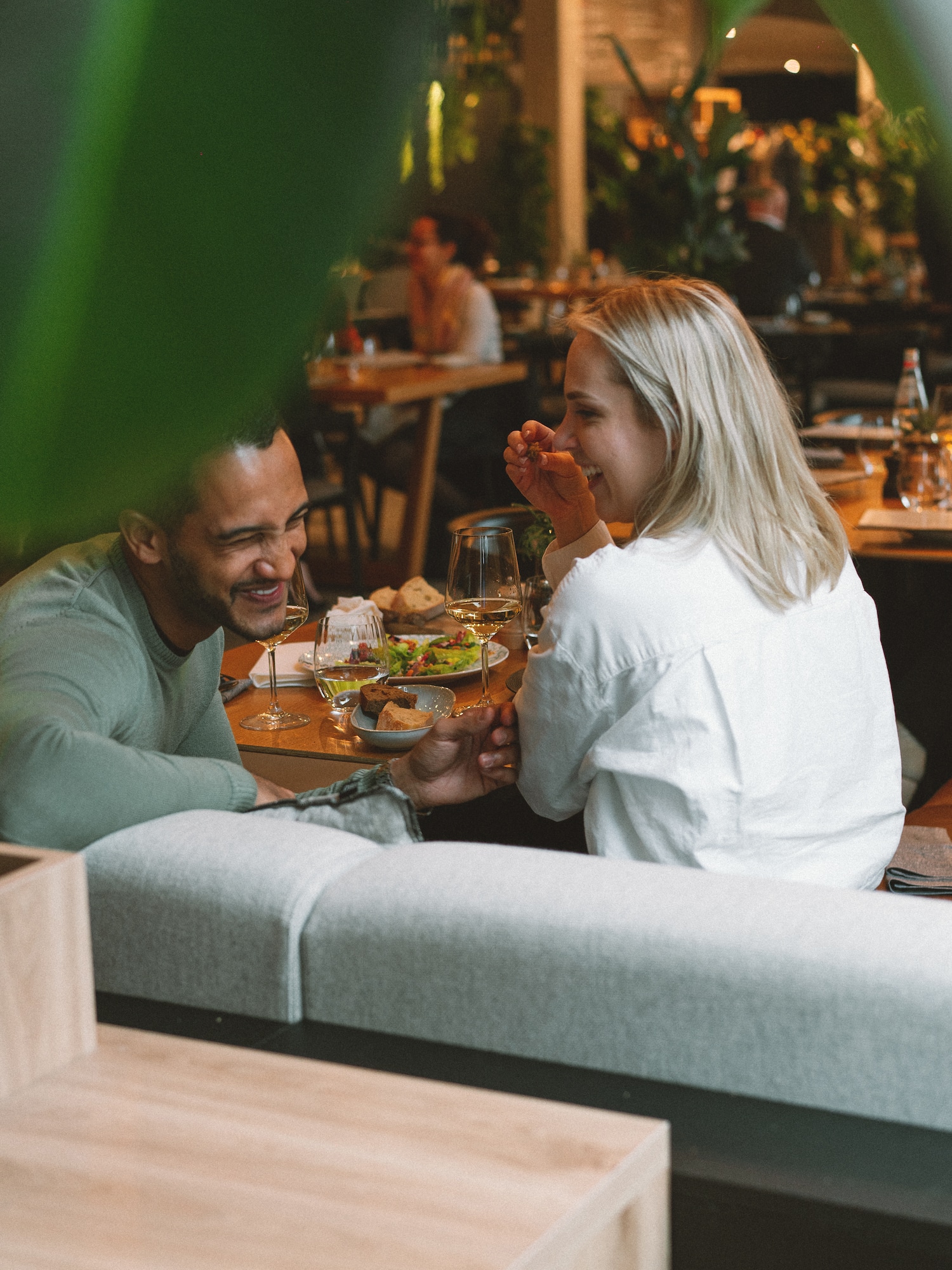 a man and woman sitting at a table with food